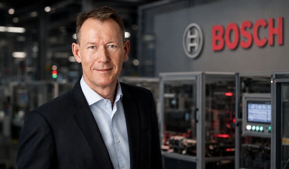 Bosch-Manager vor Produktion und Bosch-Logo: Der Konzern steht vor Umbau, Stellenabbau und hohen Investitionen