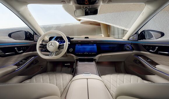 Innenraum eines Mercedes-Benz mit Lenkrad, Stern-Logo und digitalem Cockpit