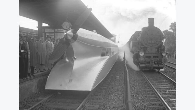 Der Schienen-Zeppelin in Berlin! Technik von gestern und heute. Ein Schnellzug auf dem Wege nach Hamburg passiert auf dem Spandauer Hauptbahnhof den soeben eingetroffenen Schienenzeppelin.