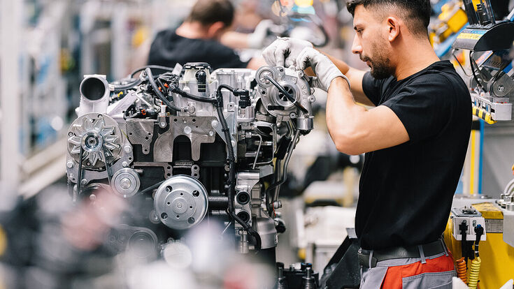 DEUTZ-Mitarbeiter montiert Motor in Produktionshalle