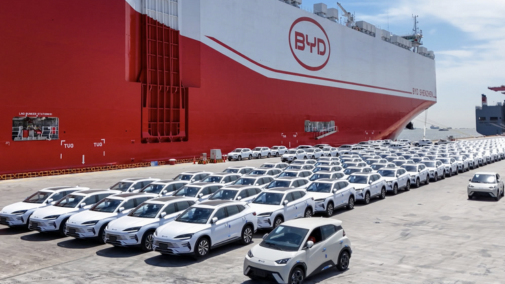 BYD-Fahrzeuge auf Halde vor einem großen Schiff mit der Aufschrift BYD