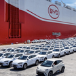 BYD-Fahrzeuge auf Halde vor einem großen Schiff mit der Aufschrift BYD