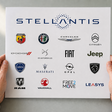 Hände halten eine Übersicht mit allen Stellantis Marken