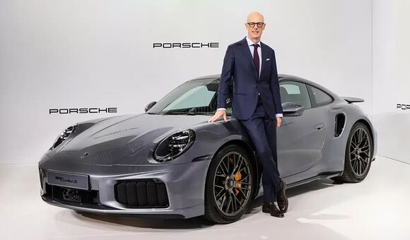 Michael Leiters neben einem Porsche Modell