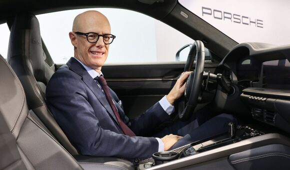 Michael Leiters Vorstandsvorsitzender bei Porsche in einem Sportwagen sitzend
