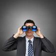 mann fernglas suche suchen feldstecher beobachten spionage spionieren schauen ausschau aussicht jobsuche job arbeit lösung entdeckung entdecken erfolg wachsam zukunft überwachen weitsicht business businessmann hemd anzug person portrait beruf hintergrund grau